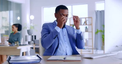 Tired Man Rubbing Eyes at Desk