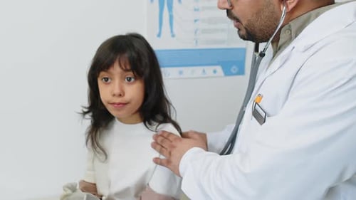 Doctor Examining Child with Stethoscope in Medical Office
