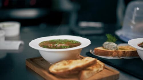 in a Professional Kitchen White Deep Plate with Soup with Dry Bread Restaurant Serving