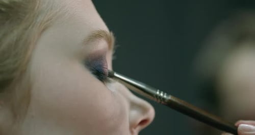 Portrait of a Pretty Girl Makeup Artist Applies Makeup for a Young Model Studio Shooting Fashion
