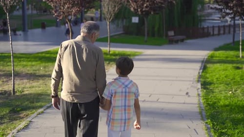 Adult and Child Walking Together in a Park