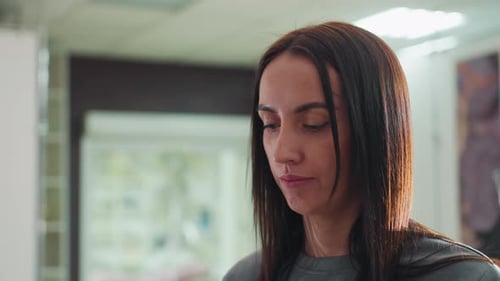 Woman Looking Down Indoors with Straight Brown Hair