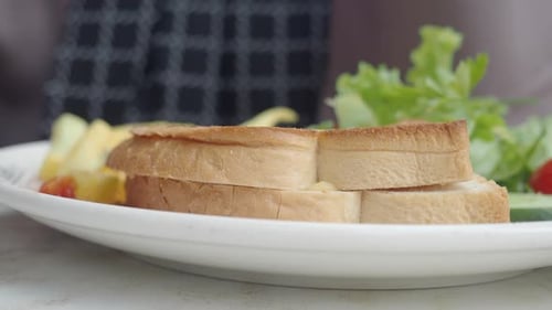 Freshly Cut Toast with a Vibrant Green Salad and Juicy Cherry Tomatoes Served on a Plate