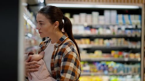 Woman Shopping with Infant at Supermarket