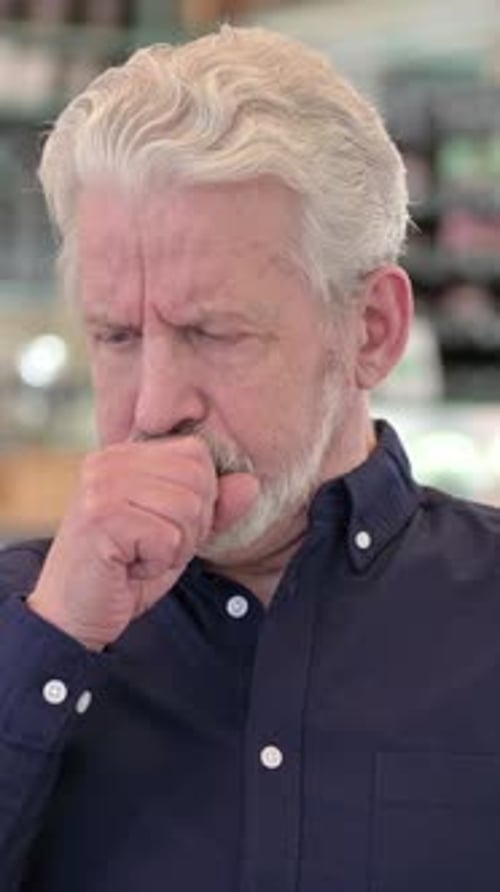Mature Man Coughing in Dark Blue Button-Down Shirt