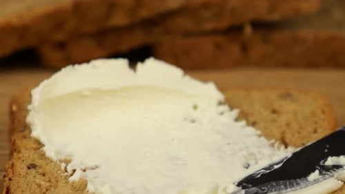 Spreading Soft White Cheese on Grain Bread