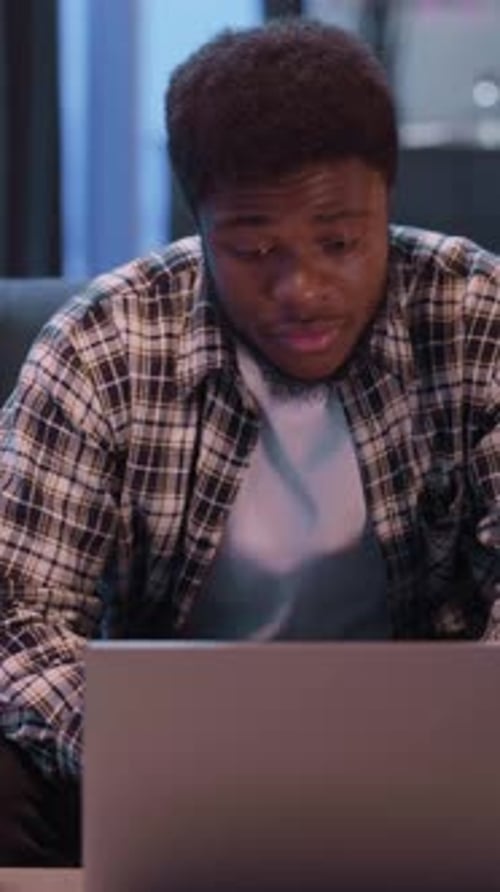 Young Adult Using Laptop Indoors at Night