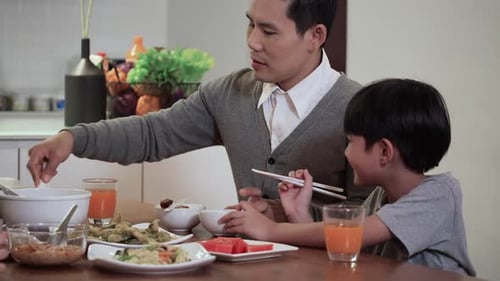 Father Serving Rice to Son at Meal