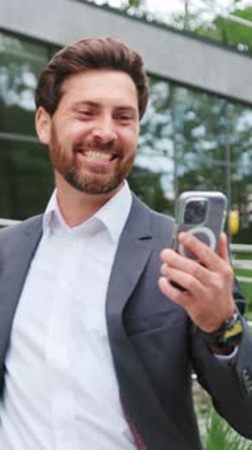 Excited Man Celebrates Success Looking at Phone Outdoors