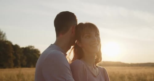 Young Attractive Couple Having a Date at Sunset in a Golden Wheat Field