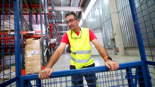 Homme portant un gilet réfléchissant de sécurité dans un entrepôt de distribution