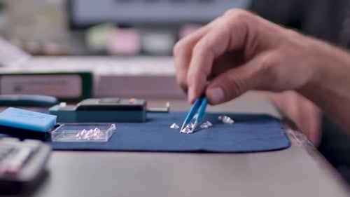 Hand Sorting Diamonds with Tweezers Close Up