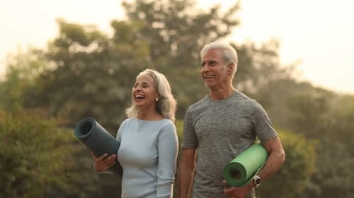 Senior Couple Enjoying Yoga Outdoors in Sunny Park