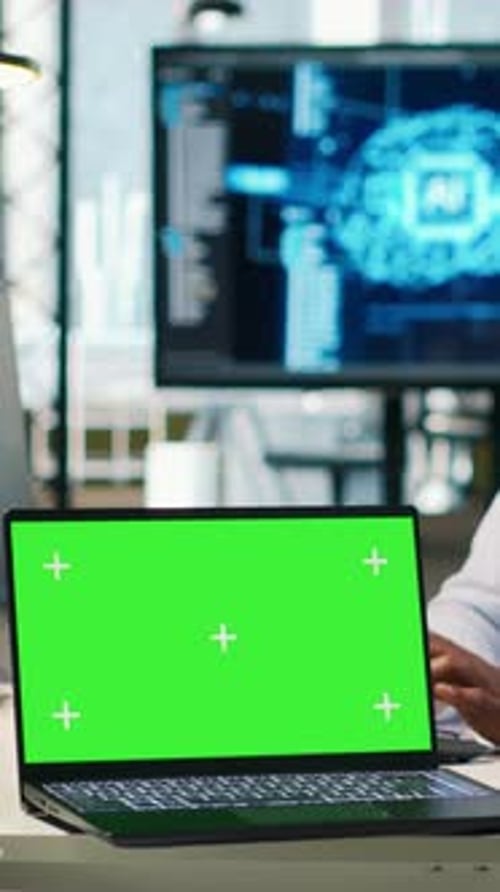 Programmeur de bureau de démarrage vidéo vertical utilisant un ordinateur portable à écran vert pour développer des modèles d'IA