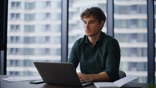 Motivierter Manager tippt Computer in moderner Büro-Nahaufnahme Professioneller Mann