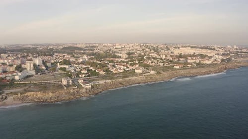 Aerial drone view overlooking the Estoril cityscape, sunset sky horizon in Lisbon