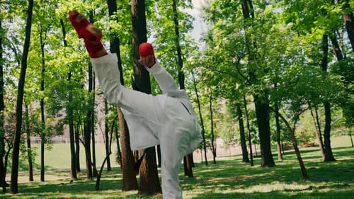 Outdoors in the Park in Sunny Weather Young Karate Guy Dressed in Red Combat Boots and Gloves