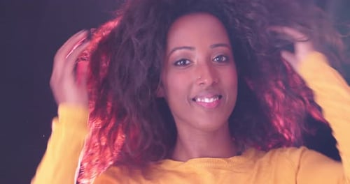 Woman Styling Curly Hair in a Fashion Portrait