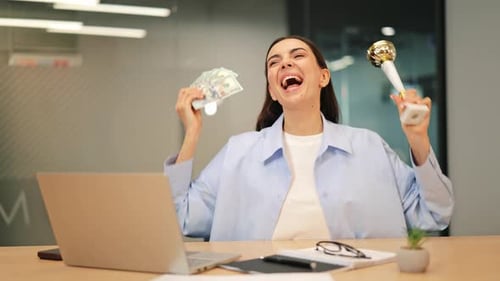 Excited Young Woman Celebrates Success with Money and Trophy