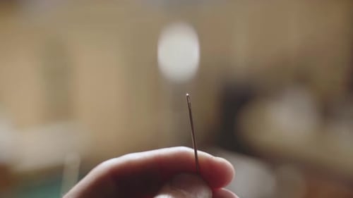 Nahaufnahme männlicher Hände Eine Nadel einfädeln, Bedienungsdetails beim Nähen und Schneidern von Männerfingern verwenden