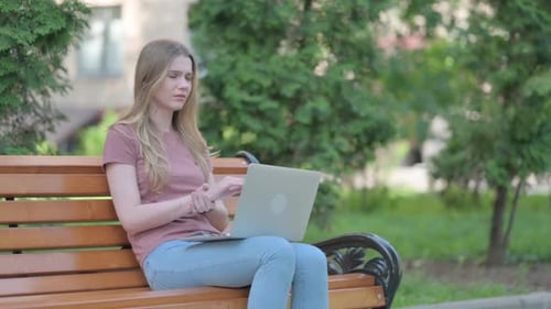 Woman Works on Laptop Outside, Massages Wrist