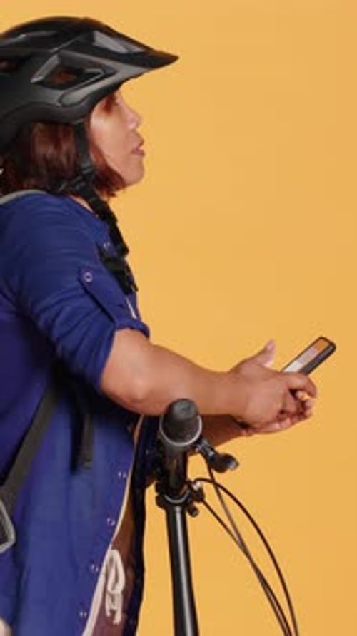 Person with bike helmet uses smartphone