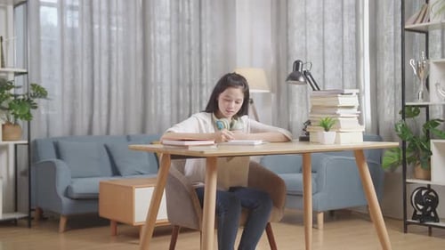 Asian Teenager Studying At Home, Asia Teen Writing While Sitting On The Table