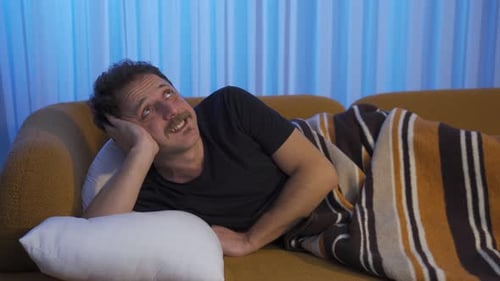 Man Lounging Comfortably on Couch at Night
