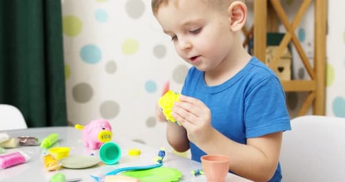 Creative Child Playing with Colorful Modeling Clay Indoors