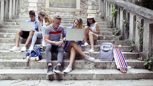 Students Using Laptops on Concrete Staircase Outdoors