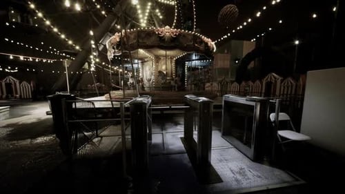 Unoccupied Fairground Area Illuminated By Festive String Lights and Reflections