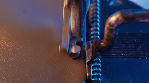 The leather craftsman produces leather products on sewing machine.Close-up of the sewing machine nee