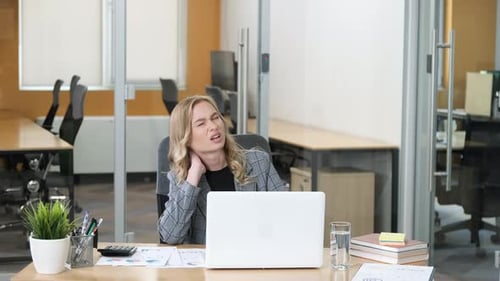 Professional Working on Her Laptop in a Modern Office