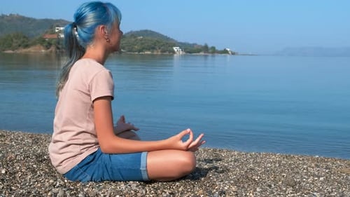 Young Person Meditating Peacefully on Beach