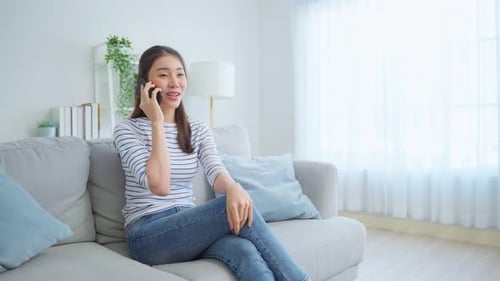 Woman Talking on Cell Phone in Bright Living Room