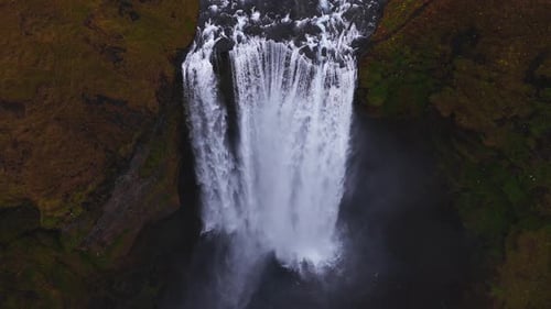 Skogafoss Waterfall Flowing Through Green Cliffs in Iceland