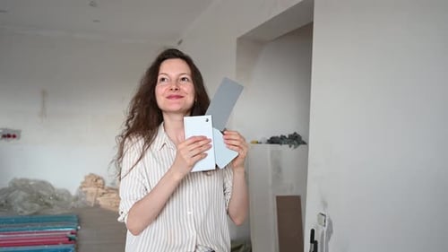 Home Renovation Woman Selecting Paint Colors for Unfurnished Room