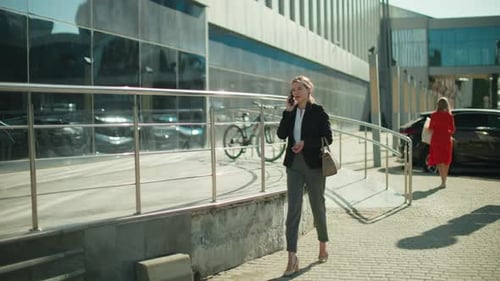 Professional Business Woman Walking Home While Talking on Phone in Urban Area