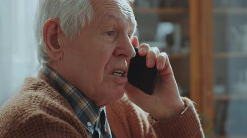 Senior Man Talking on Smartphone Indoors
