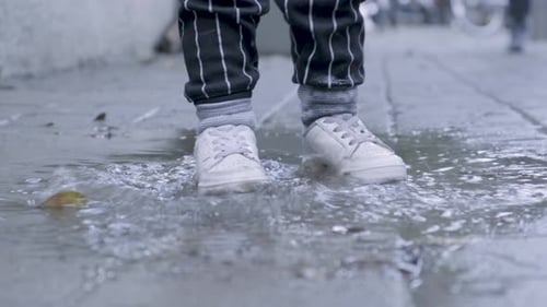 Child Splashes Happily in a Puddle