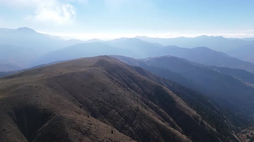 Crêtes de Grammeni Oxia et montagnes bleues sous un ciel clair avec un terrain rocheux