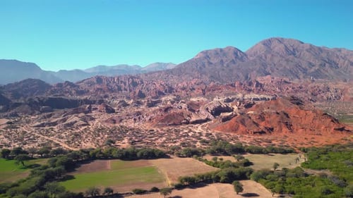 Aerial view drone flying over scenic red rocky mountains and green valleys.