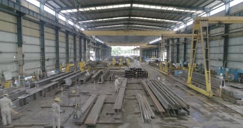 Arbeiter, die in einem Gebäude für die industrielle Metallherstellung arbeiten. - Luftbild
