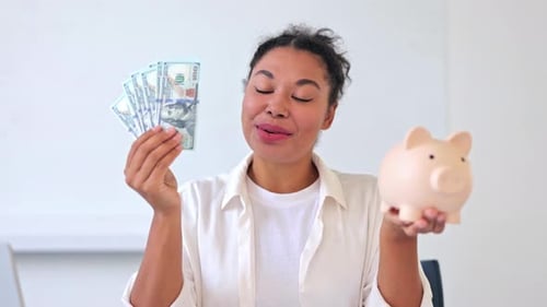 Empresária feliz com dinheiro e cofrinho