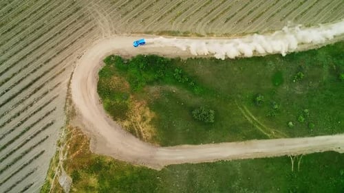 Aerial View of a Beautiful Curved Dirt Road Winding Through Lush Green Farmland Landscape Media