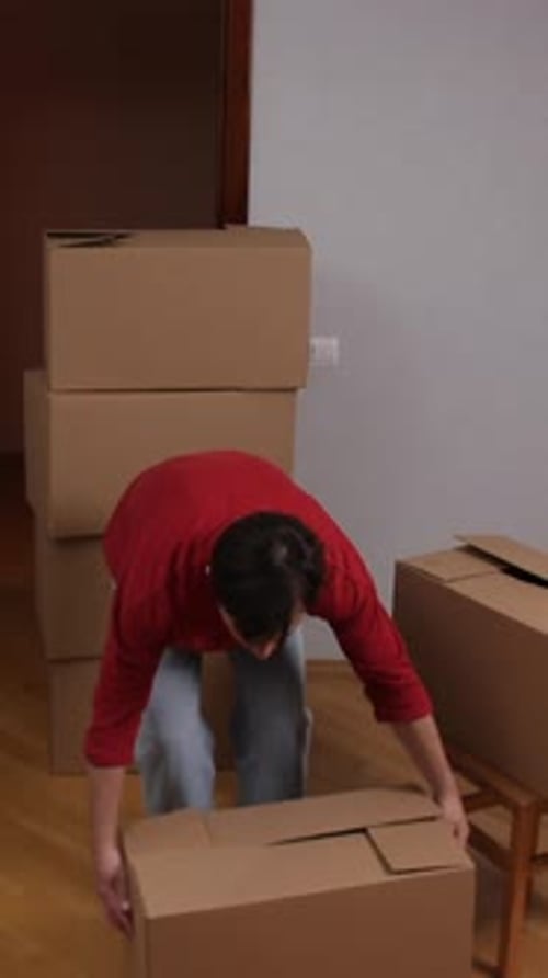 Young Man Moving Boxes Indoors