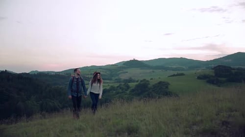 Couple Walking Holding Hands in Mountain Landscape at Sunset