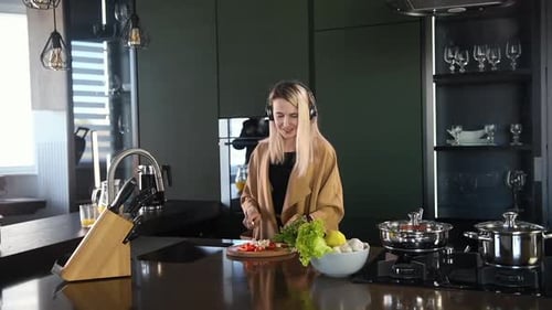 Cheerful Woman Cooking and Chopping Vegetables in Kitchen