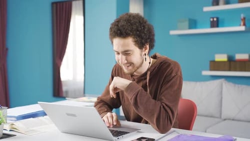 Young Adult Works on Laptop and Takes Notes