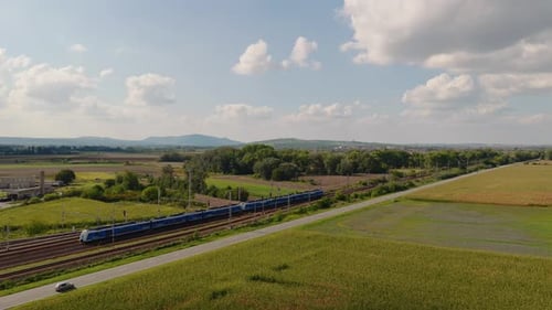Drone view of train traveling through farmland